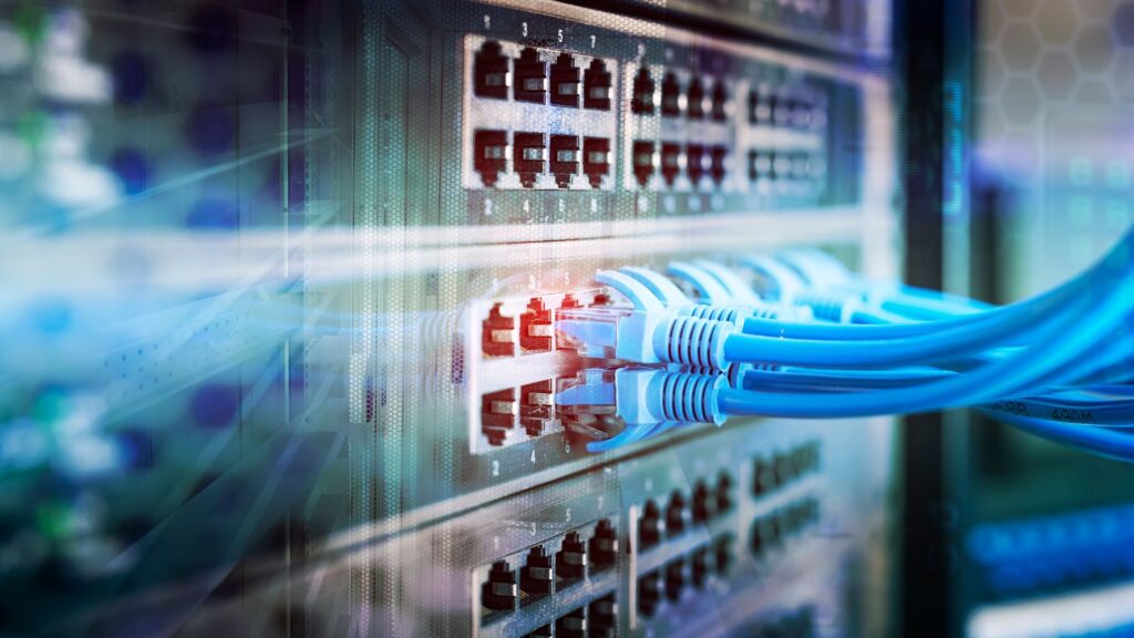 Close-up of blue Ethernet connection cables plugged into a Lenovo server rack with indicator lights, representing data transfer and network connectivity.