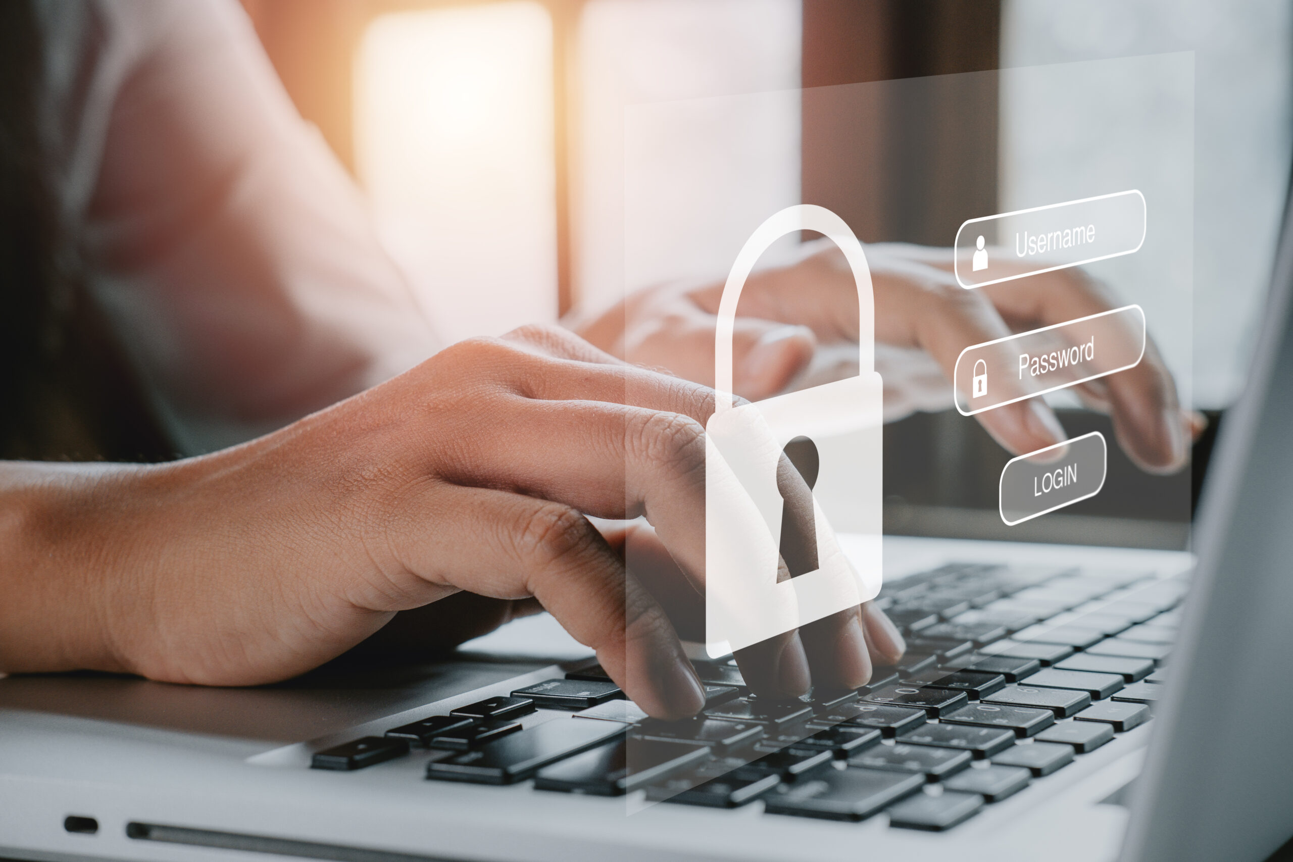 Hands typing on a laptop keyboard with a digital overlay of a padlock and login fields for username and password, symbolizing what is conditional access system protection.